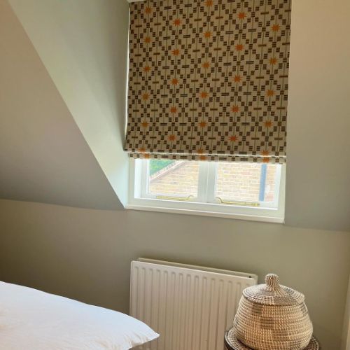 Patterned roller blinds in a bedroom window