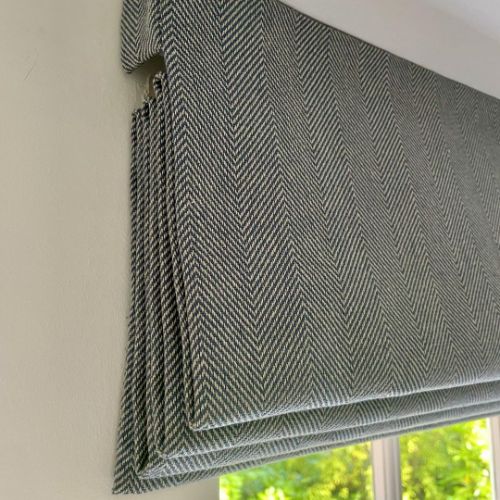 Textured gray roller blind in a window